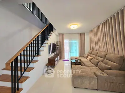 Spacious living room with modern staircase and cozy seating area