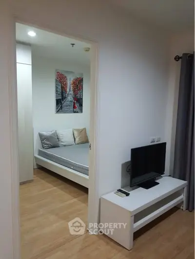 Cozy and modern studio apartment with a comfortable daybed, sleek TV unit, and elegant wooden flooring, perfect for urban living.