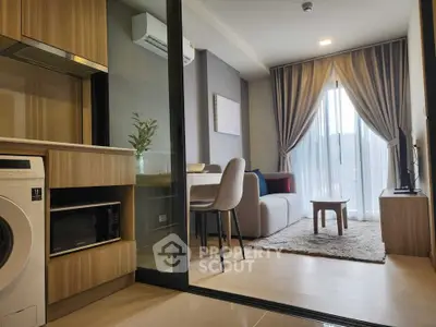 Modern living room with open kitchen, featuring stylish furniture and natural light.