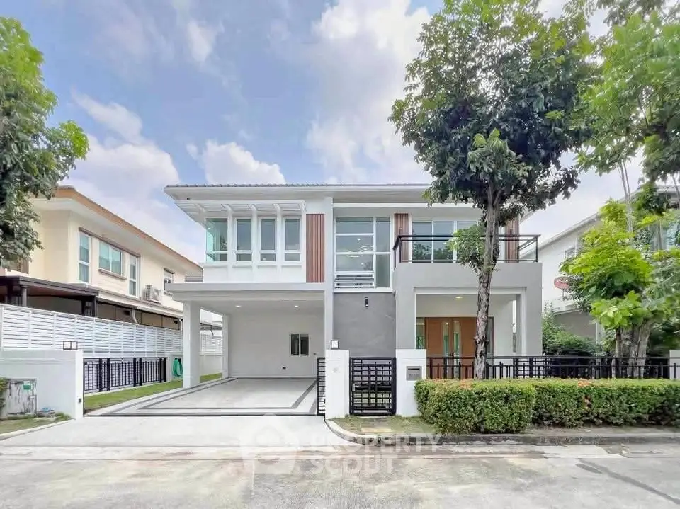 Modern two-story house with sleek design and spacious driveway in a serene neighborhood.