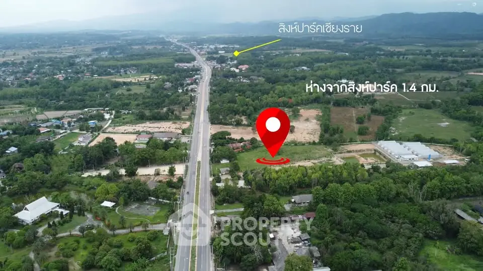 Scenic aerial view of potential real estate development site with lush greenery and road access.