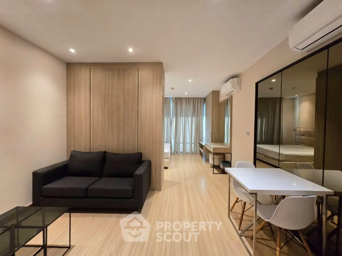 Modern living room with sleek furniture and wooden flooring in a stylish apartment.