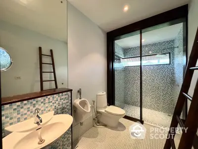 Modern bathroom with mosaic tiles and glass shower enclosure