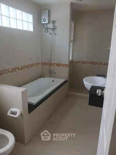 Spacious bathroom with bathtub and modern fixtures in a stylish home.