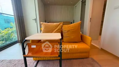 Modern living room with vibrant yellow sofa and sleek side table, featuring a cozy ambiance and stylish decor.