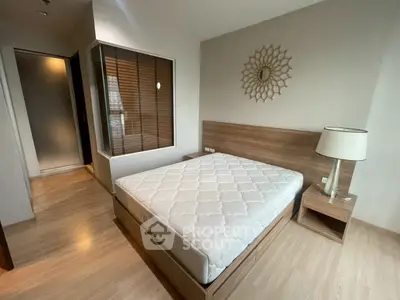 Modern bedroom with stylish decor and wooden flooring, featuring a comfortable bed and elegant lighting.