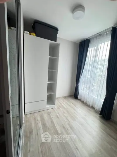 Bright bedroom with large windows and modern wardrobe in a high-rise apartment.