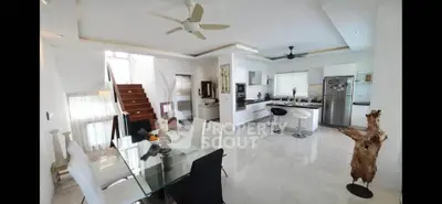 Spacious modern open-plan kitchen and dining area with sleek design and natural light.