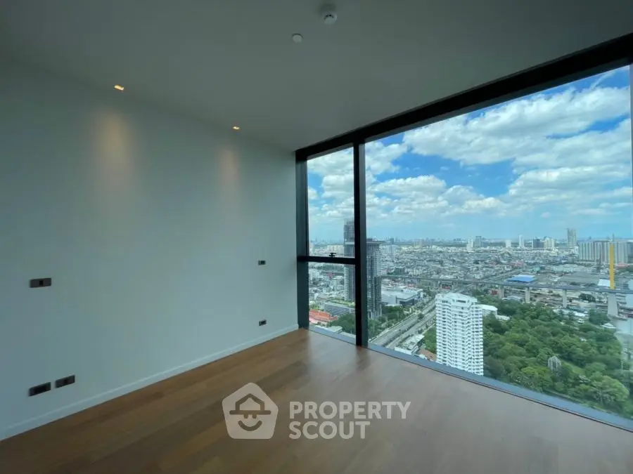 Stunning high-rise apartment with panoramic city views and sleek wooden flooring.
