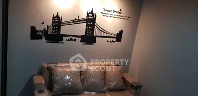 Cozy living room with stylish wall art of Tower Bridge and plush sofa.