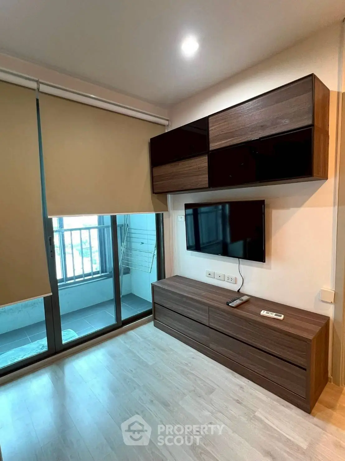 Modern living room with sleek wooden furniture and balcony access
