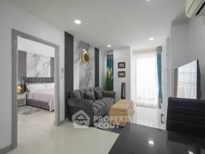 Modern living room with elegant decor and adjacent bedroom in a stylish apartment.