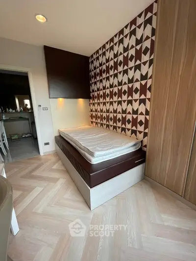 Stylish bedroom with geometric accent wall and cozy single bed