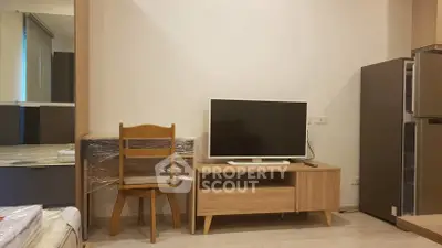 Modern apartment interior with TV, wooden furniture, and sleek design.