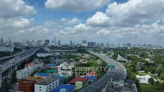 Stunning cityscape view with highways and vibrant skyline under a cloudy sky.