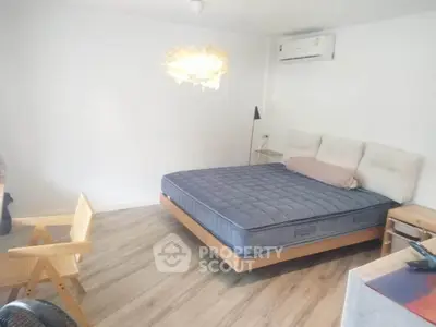 Spacious bedroom with modern decor and cozy lighting, featuring a comfortable bed and stylish furnishings.