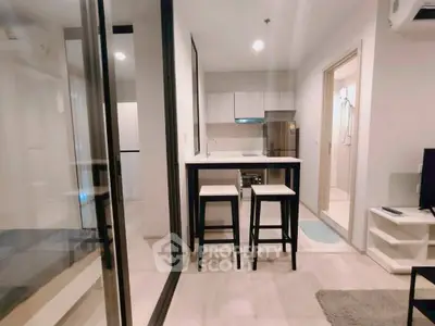Modern open-layout kitchen with sleek design and bar seating in a cozy apartment.