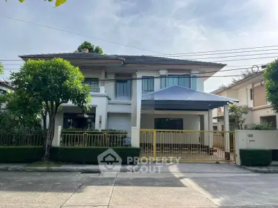 Charming two-story house with a spacious driveway and lush greenery in a serene neighborhood.