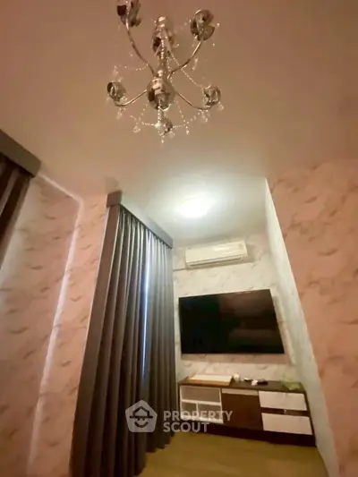 Luxurious living room with elegant chandelier and modern TV setup