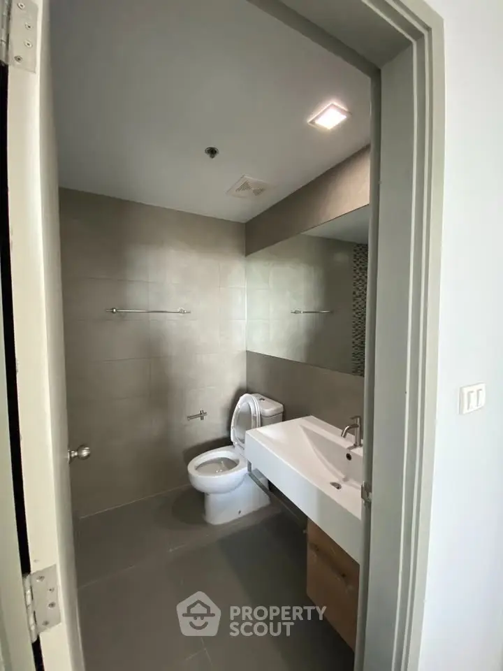 Modern bathroom with sleek fixtures and large mirror in a contemporary home.