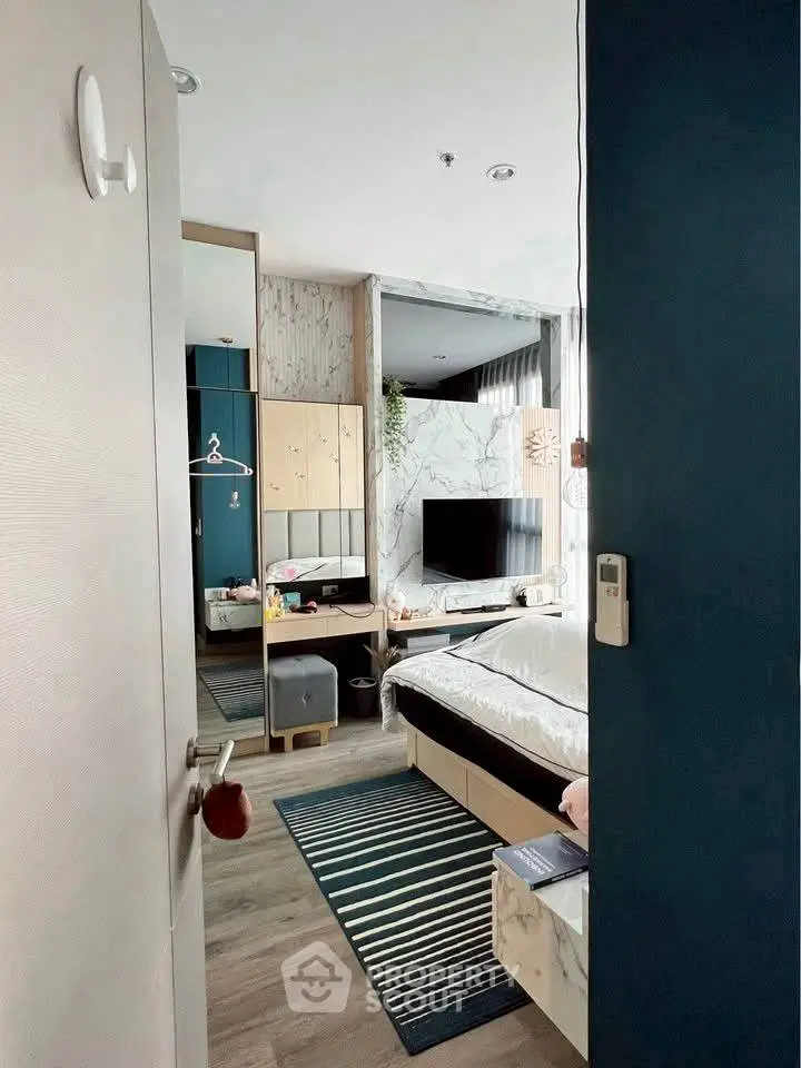 Modern bedroom with stylish decor, featuring a cozy bed, wall-mounted TV, and elegant furnishings.