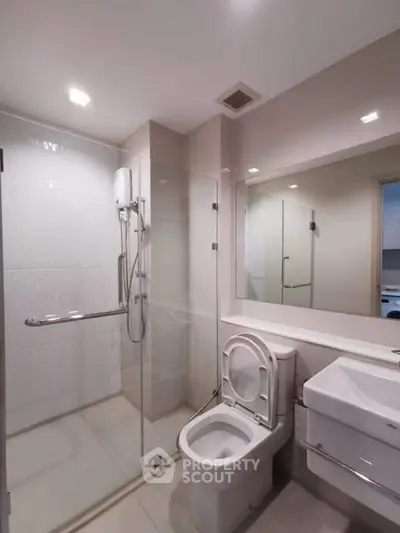 Modern bathroom with glass shower and sleek fixtures in a contemporary apartment.