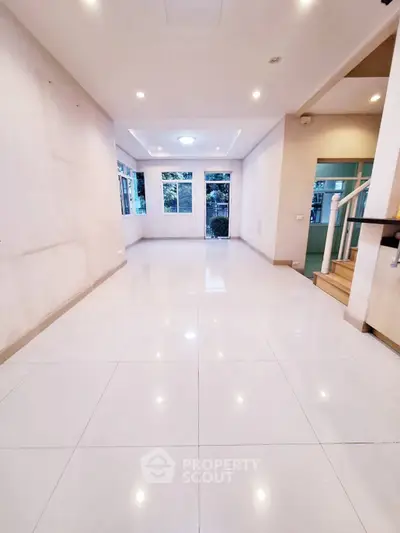 Spacious and bright living room with modern tile flooring and large windows.