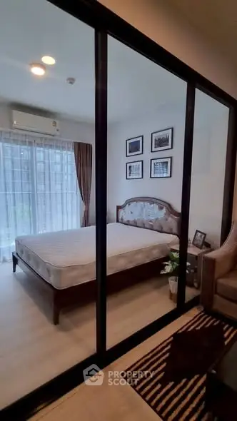 Elegant bedroom with glass partition, cozy decor, and natural light