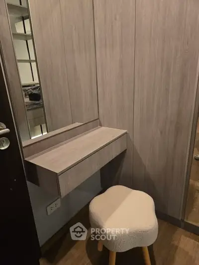 Modern minimalist vanity area with wooden paneling and cozy stool in stylish apartment.