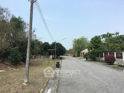 Quiet suburban street with lush greenery and residential homes, ideal for peaceful living.