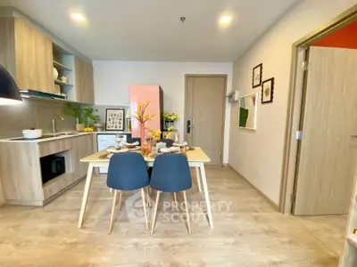Modern open-layout kitchen and dining area with stylish decor and wooden flooring.