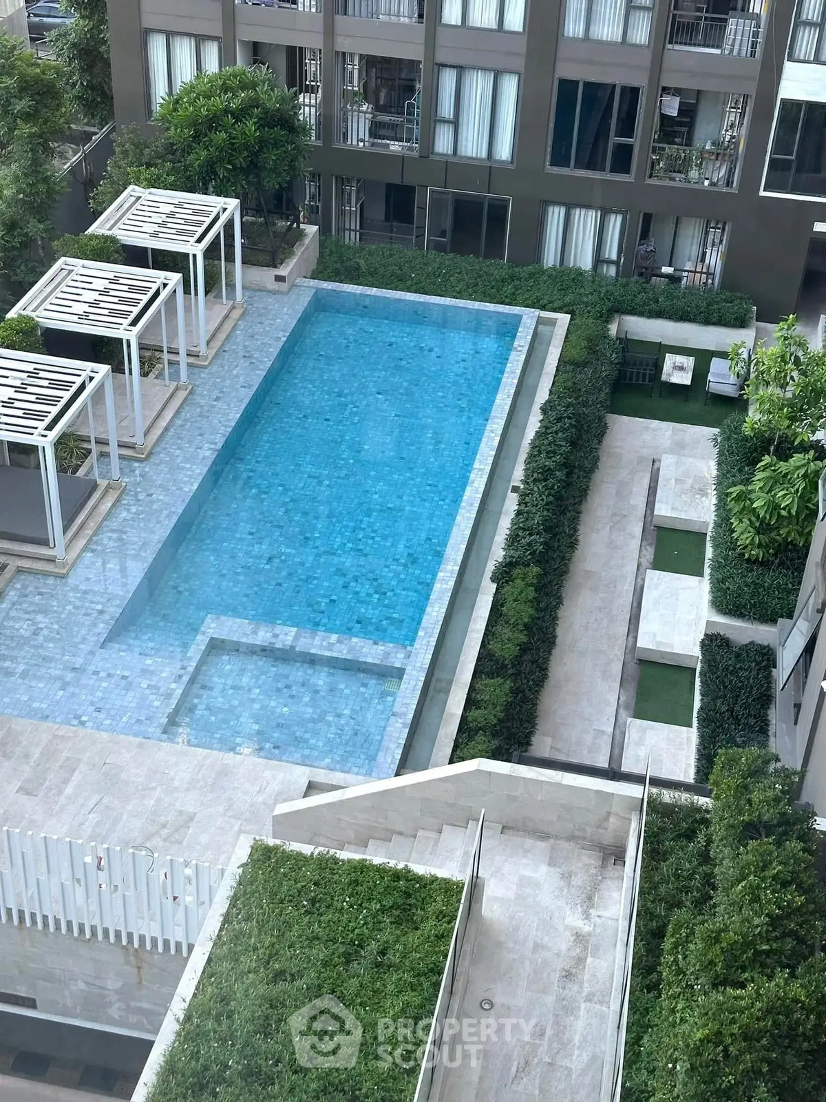 Luxurious condominium with stunning pool and lush greenery, perfect for relaxation and leisure.