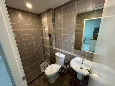 Modern bathroom with sleek tiles and contemporary fixtures in a stylish real estate property.