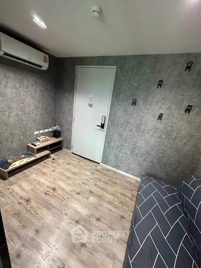 Modern living room with stylish decor and wooden flooring, featuring a sleek air conditioning unit.