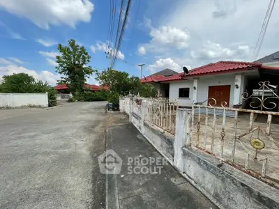 Charming suburban house with red roof and spacious driveway in a peaceful neighborhood.