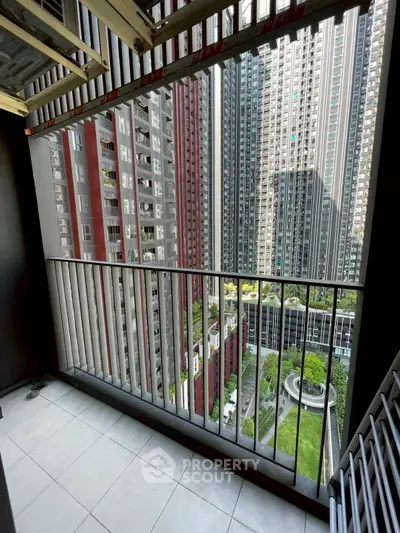 Modern high-rise balcony with stunning cityscape view and lush green courtyard below.