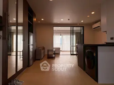Spacious modern living room with open layout and sleek design, featuring large windows and stylish furnishings.