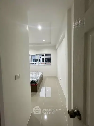 Modern minimalist bedroom with sleek tile flooring and ample natural light