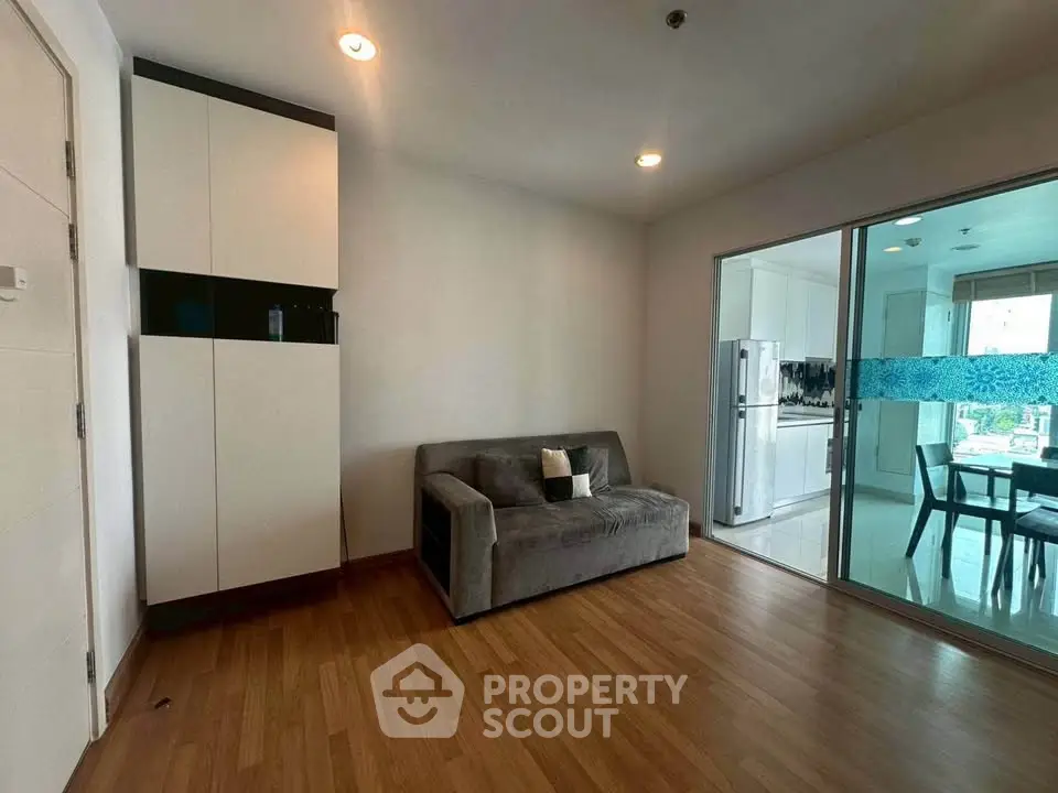 Modern living room with sleek design and adjacent kitchen view.