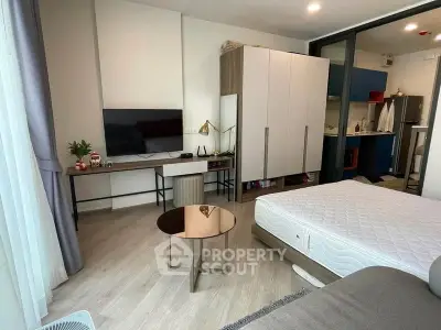 Modern studio apartment with sleek design and open layout, featuring a cozy living area and compact kitchen.