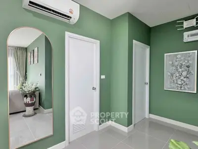 Stylish modern apartment interior with green walls and air conditioning, featuring a cozy living area and elegant decor.