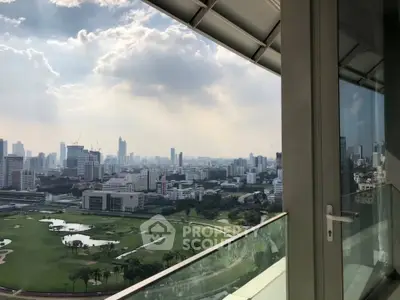 Stunning cityscape view from a high-rise balcony overlooking a golf course and skyline.