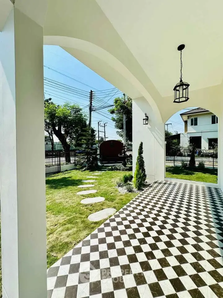 Charming garden view from elegant archway with checkered flooring