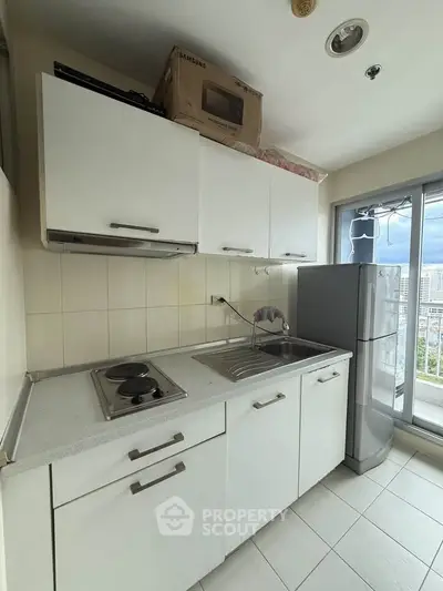 Compact kitchen with modern appliances and city view from window