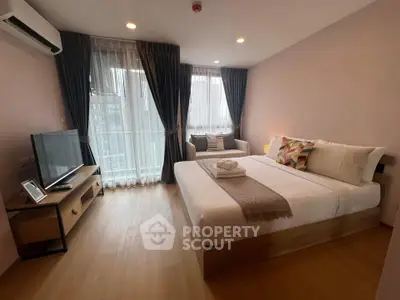 Modern bedroom with cozy decor and natural light in a stylish apartment.