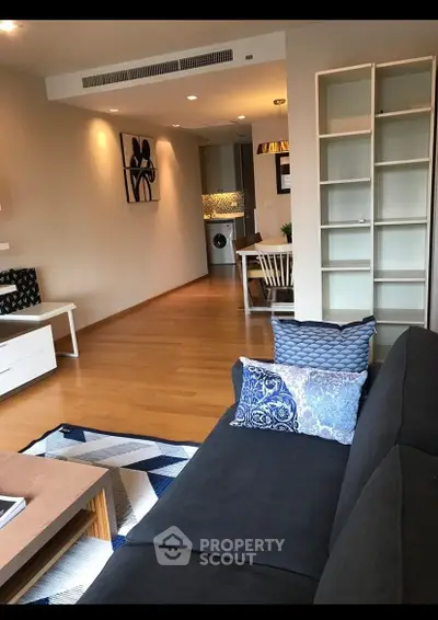 Modern living room with stylish decor and open layout leading to dining area and kitchen.