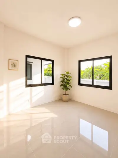 Bright and airy room with large windows and a potted plant, perfect for a serene living space.