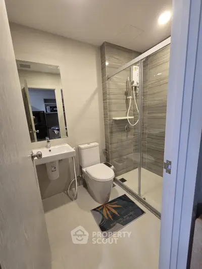 Modern bathroom with glass shower and sleek fixtures in a contemporary apartment.