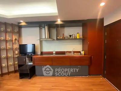 Modern kitchen with sleek cabinetry and integrated TV in stylish apartment