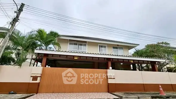 Charming two-story house with spacious front yard and lush greenery.